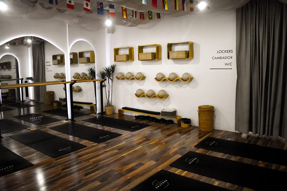 Salón de Breathe Wellness Studio con barras y colchonetas